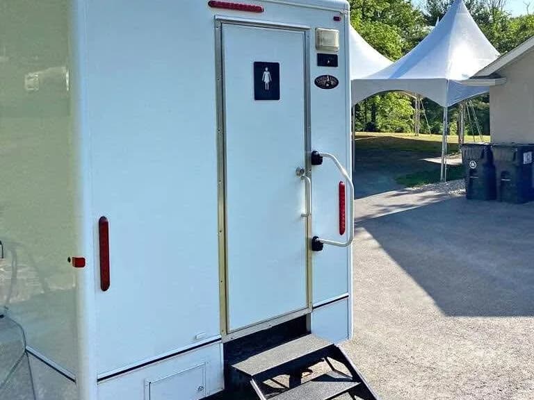 Restroom trailer with its entry steps down at an outdoor venue