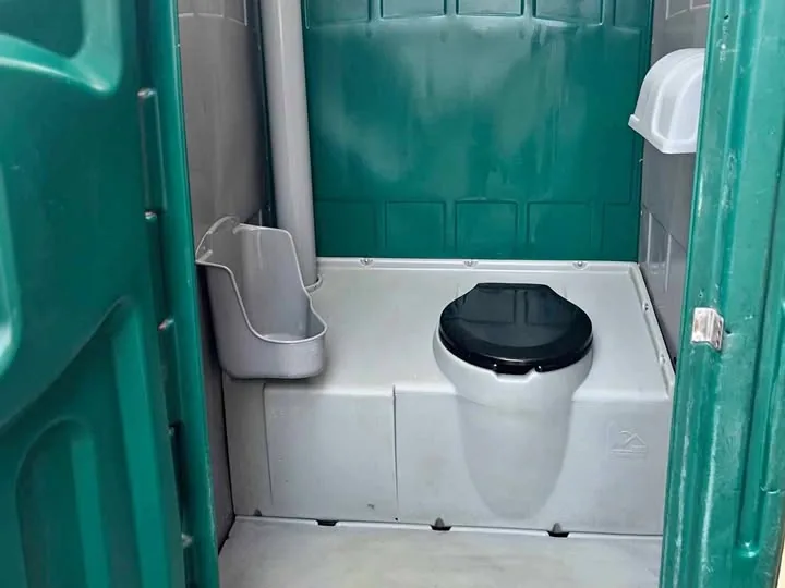 Interior of a standard portable restroom with a urinal and toilet